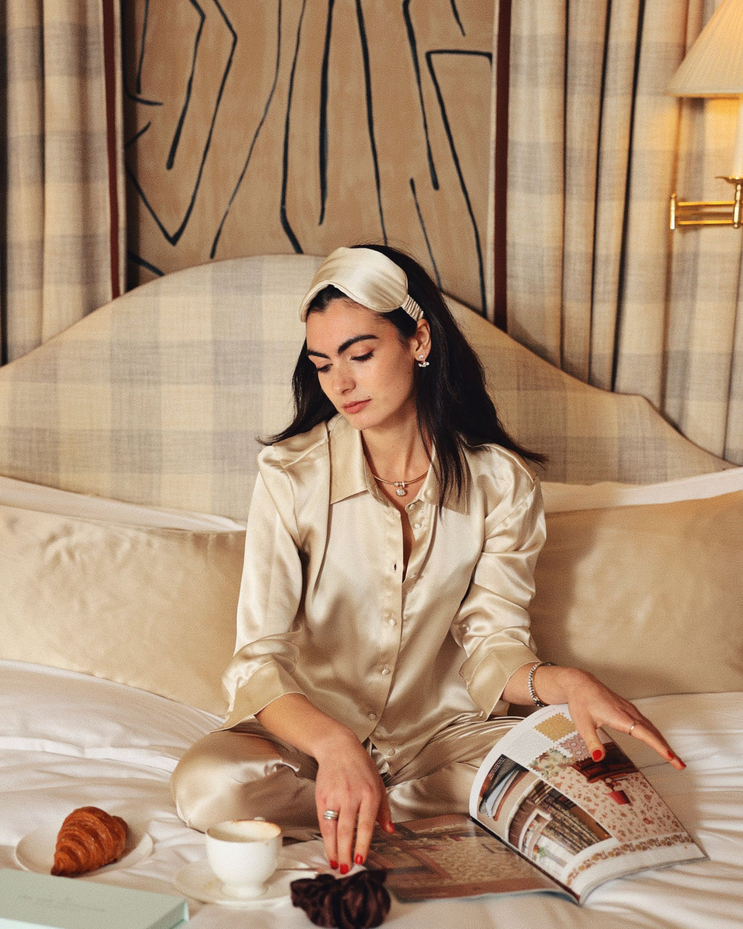 Champagne silk eye mask on head cross legged breakfast in bed