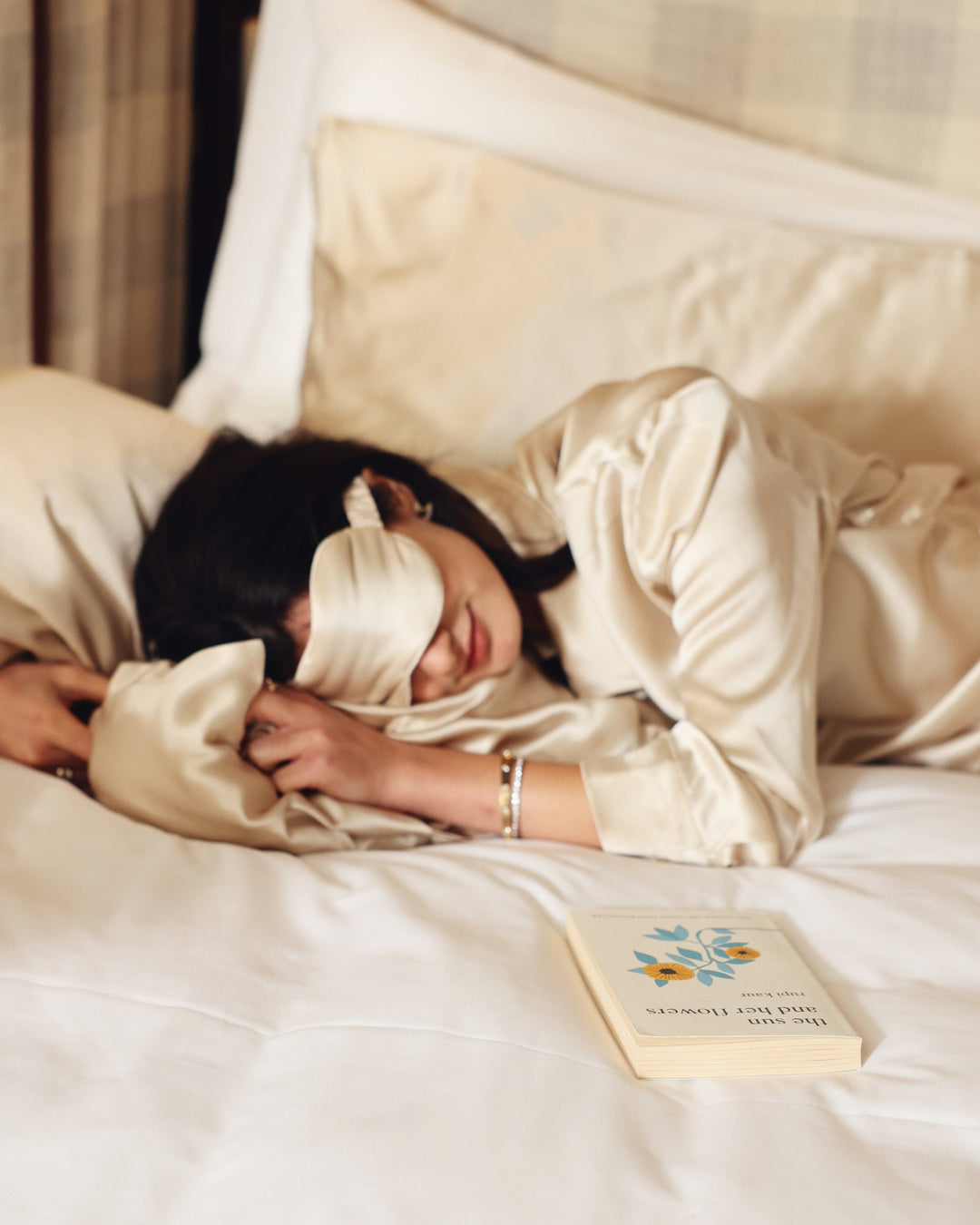 Champagne silk eye mask worn asleep in bed book