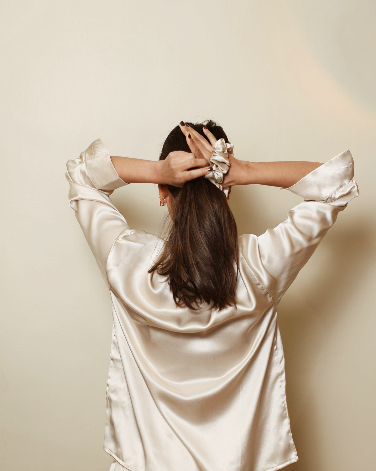 Champagne silk scrunchie tying hair back view champagne shirt