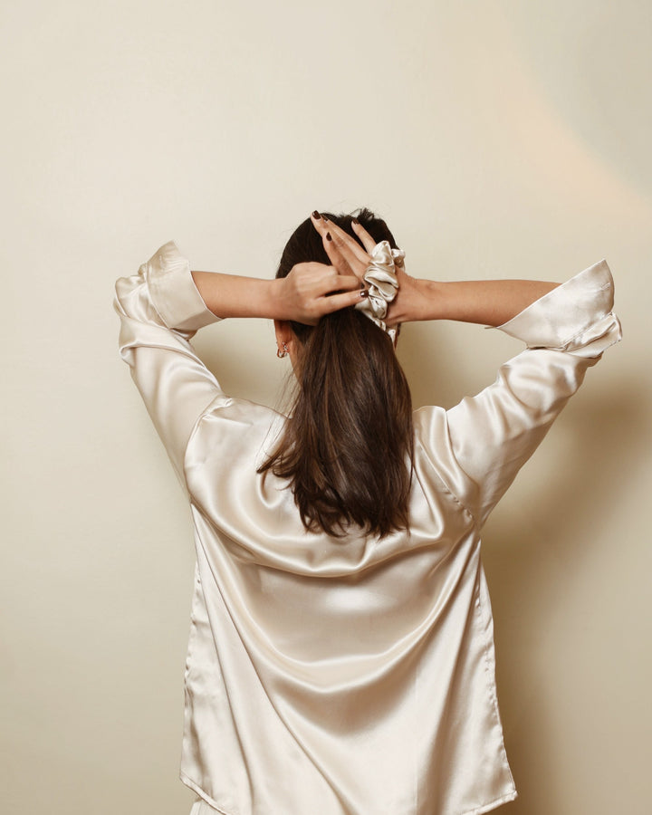 Champagne silk scrunchie tying hair back view champagne shirt