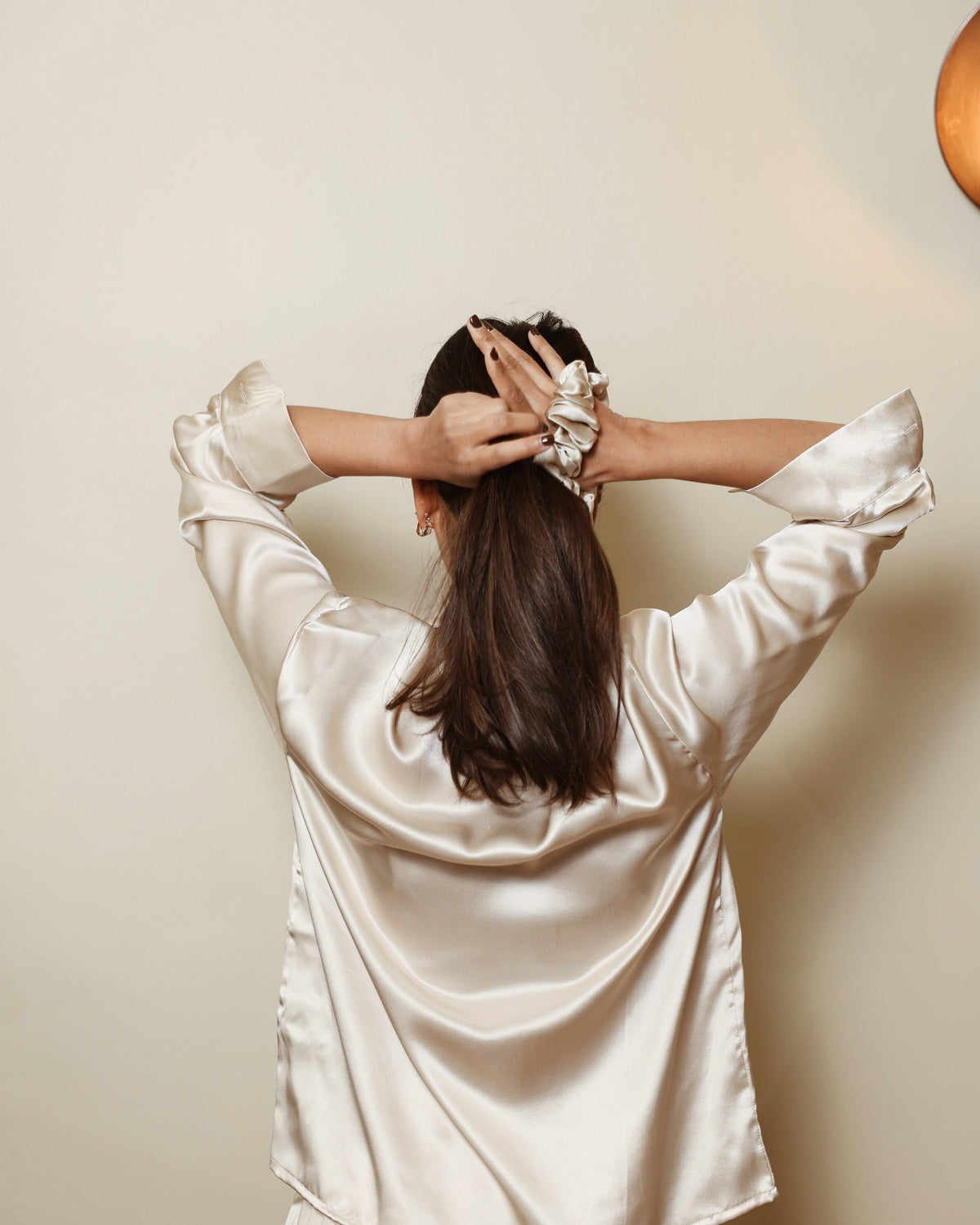 Champagne silk scrunchie tying hair back view champagne shirt