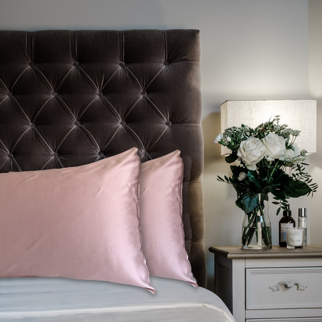 Blush Pink mulberry silk pillowcases for hair and skin, 22 momme 100% silk, on a velvet headboard | The Silk Collection