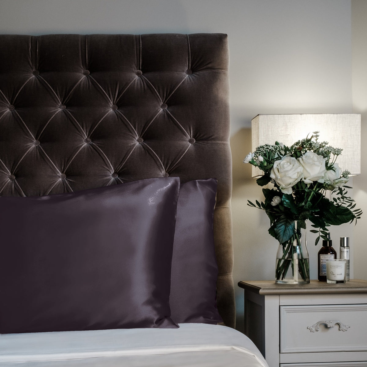 Charcoal Grey mulberry silk pillowcases for hair and skin, 22 momme 100% silk, on a velvet headboard | The Silk Collection