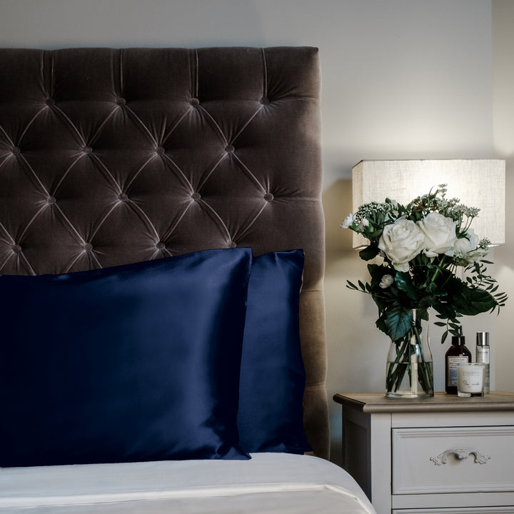 French Navy mulberry silk pillowcases for hair and skin, 22 momme 100% silk, on a velvet headboard | The Silk Collection