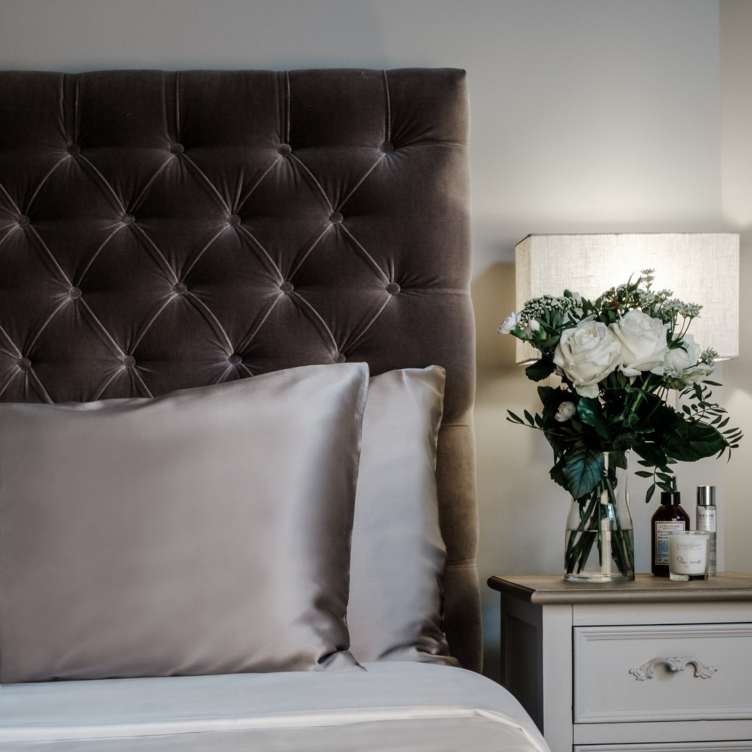 Oyster mulberry silk pillowcases for hair and skin, 22 momme 100% silk, on a velvet headboard | The Silk Collection