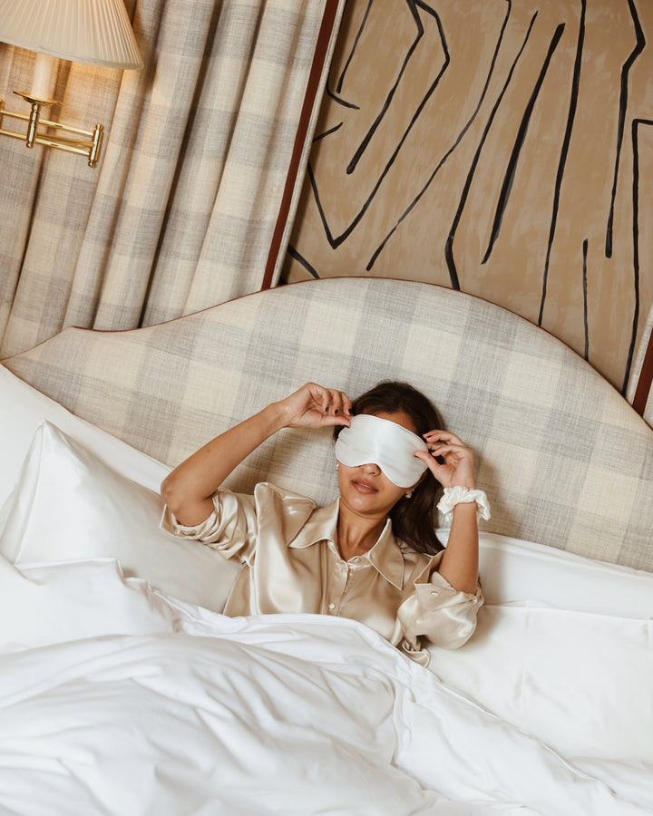 Pearl white silk eye mask putting on in bed