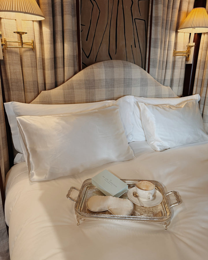 Pearl white silk pillowcases bed still life champagne eye mask tray gift box