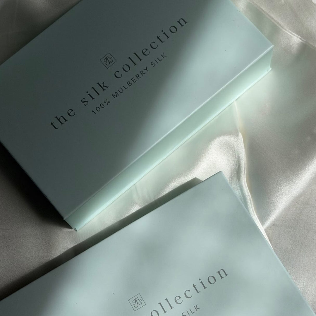 The Silk Collection signature gift boxes on silk in morning sunlight