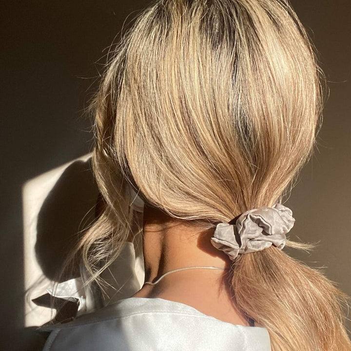 Hair tied in a low ponytail with a classic silk scrunchie