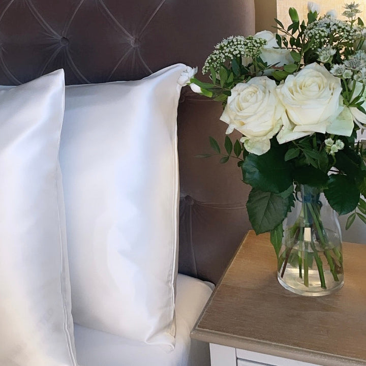 Pearl white 22 momme mulberry silk pillowcases on a velvet headboard | The Silk Collection